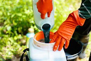 Chemicals are poured into a sprayer tank