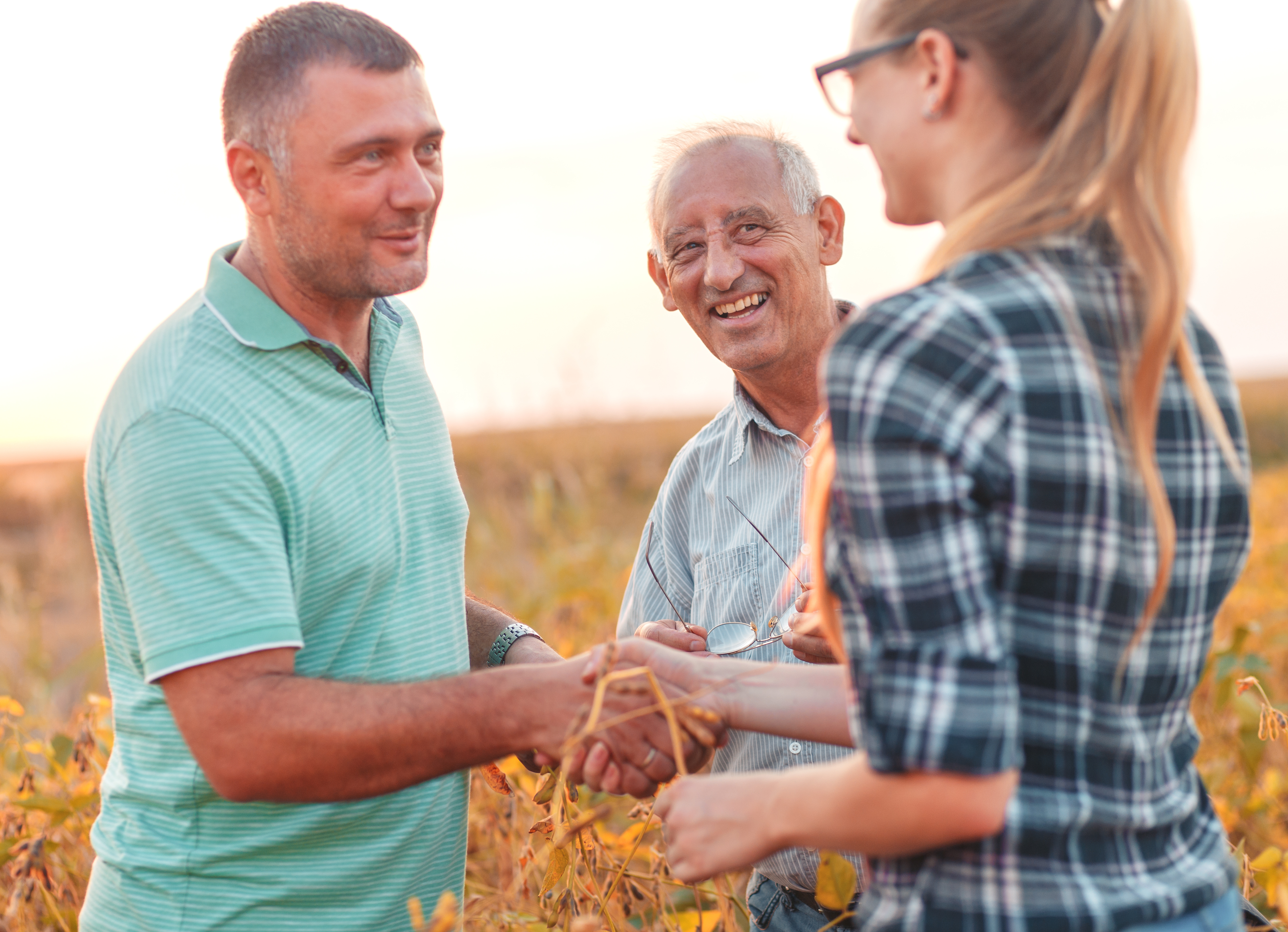 farm sale between two people with elder looking at them with a smile